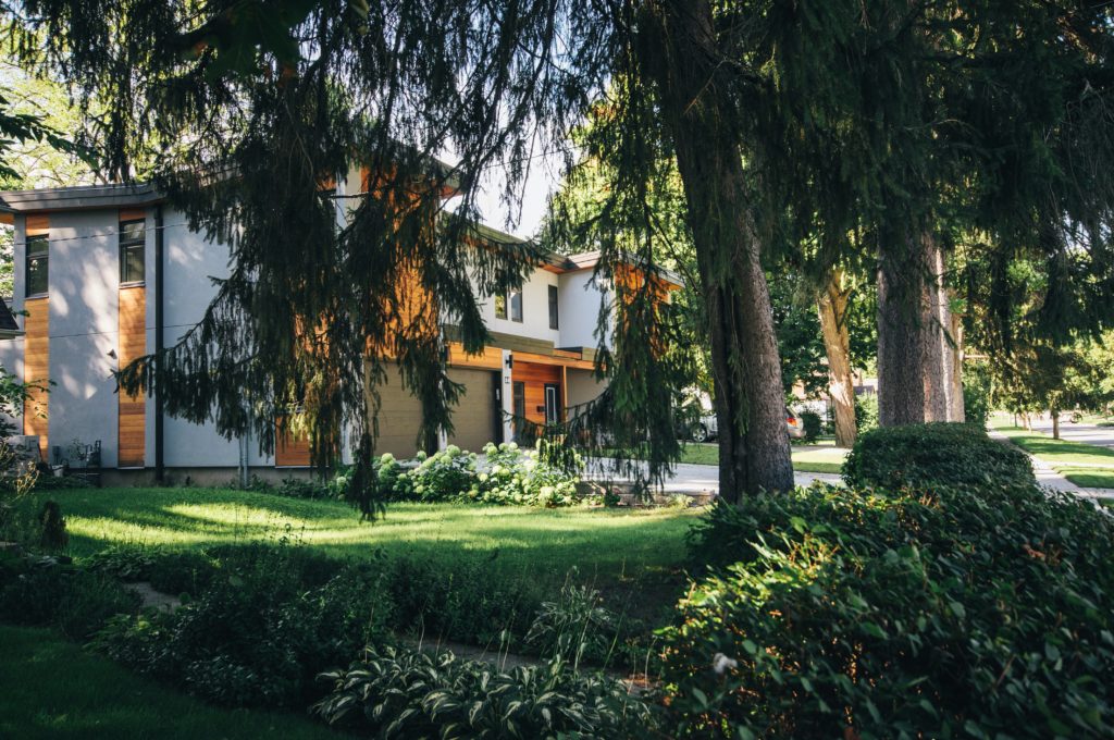 Фото дома с деревьями, кустами и лужайкой перед домом